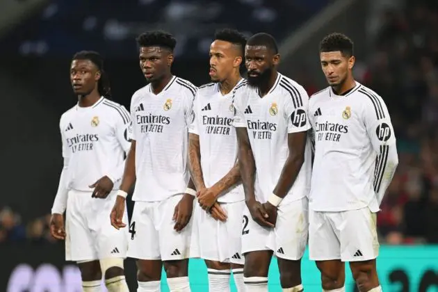 Real Madrid players stand in a wall.