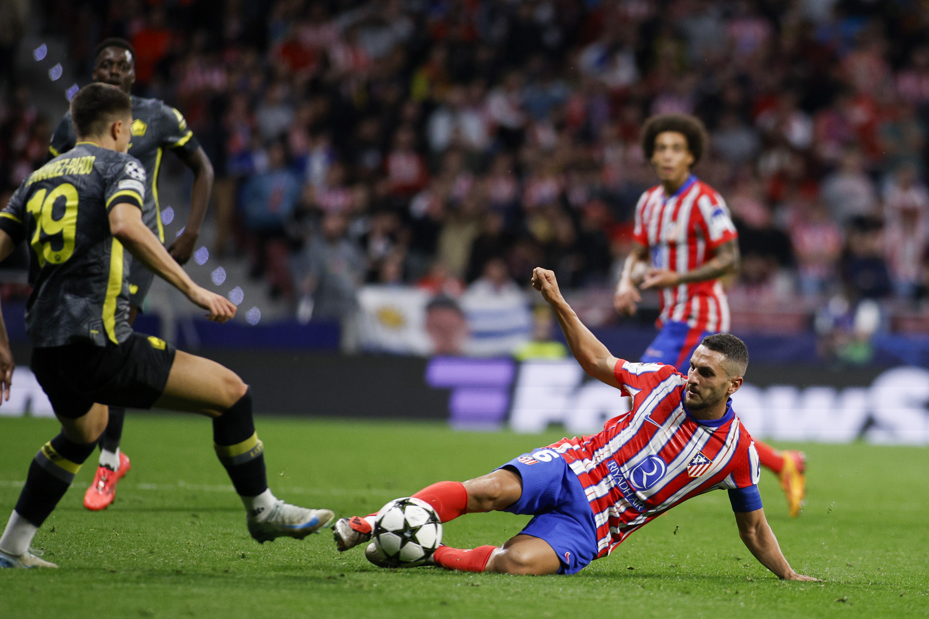 Koke goes into a tackle.