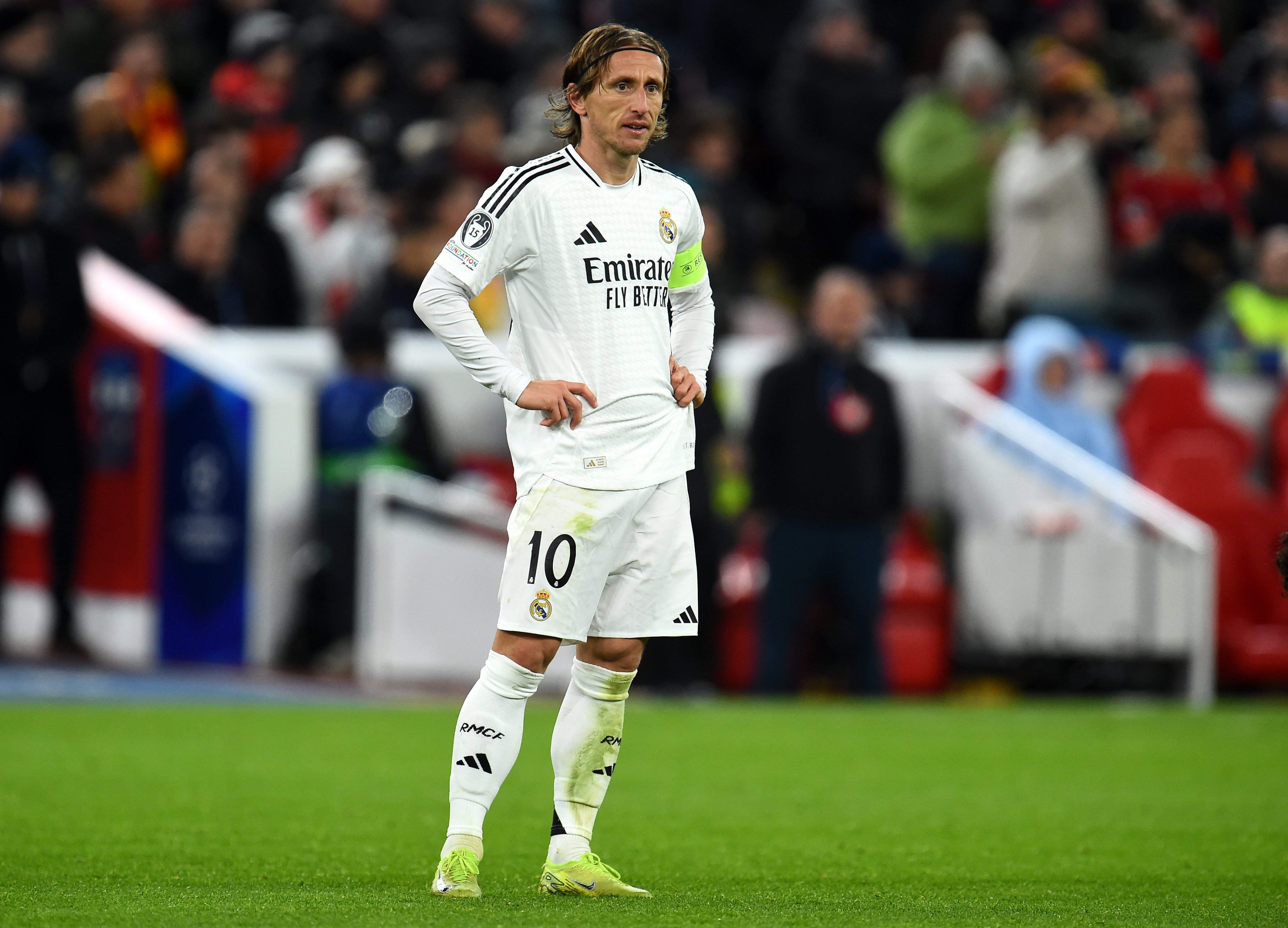 Luka Modric stands with hands on hips.