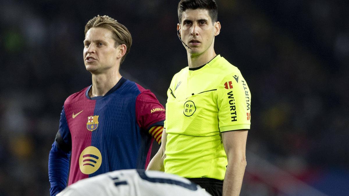 De Jong looks irritated next to the referee.