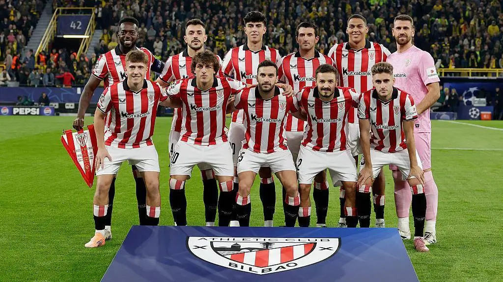 Athletic Bilbao football team posing for a photo with their logo in the foreground.