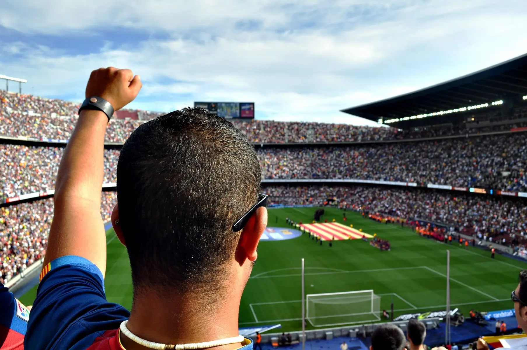 Fan cheering in a crowded stadium during a Barcelona match.