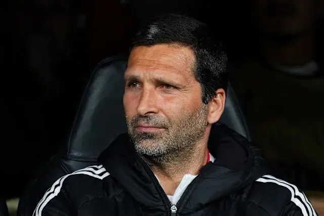 Close-up of Coach Joao Tralhao sitting on the bench during a match.