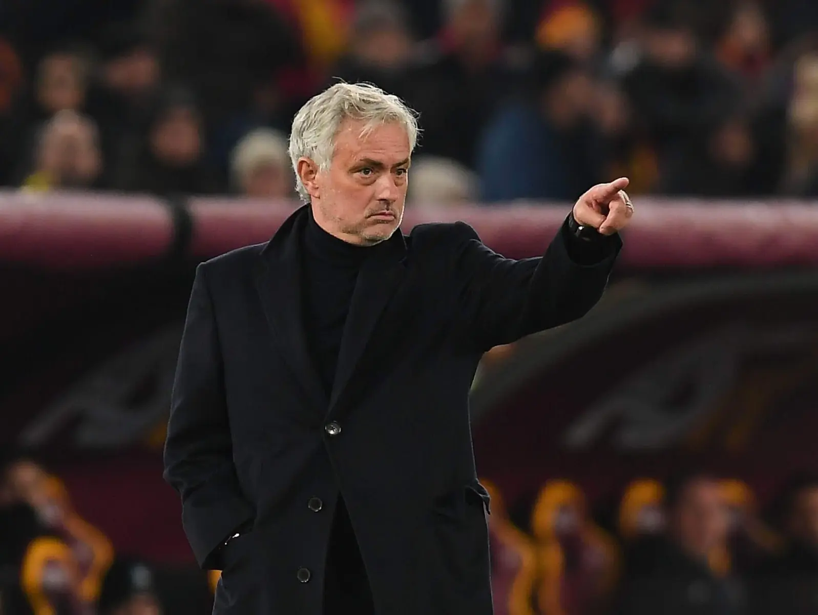 José Mourinho faz gestos laterais em uma partida de futebol.