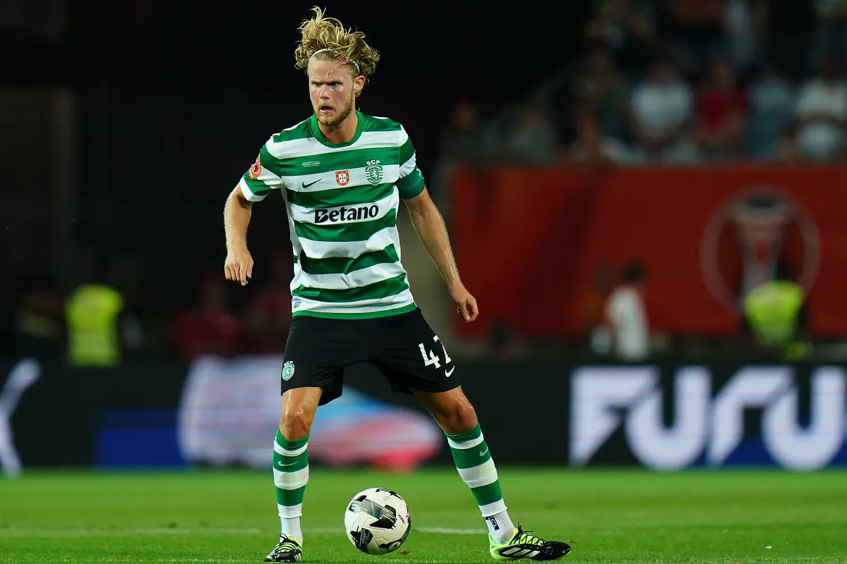 Morten Hjulmand in Sporting CP kit dribbling a football during a match.