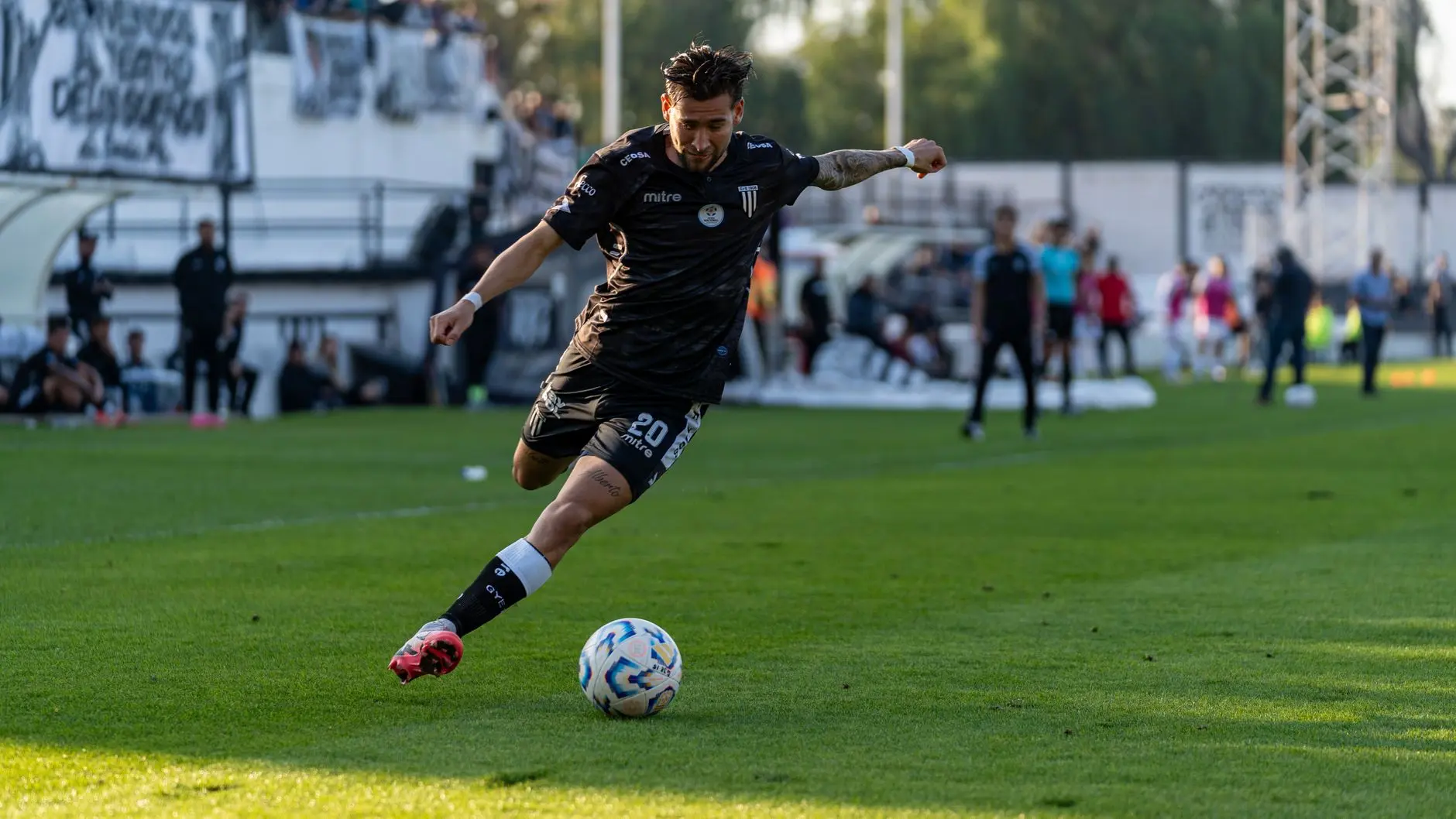 Marc Domenech in a black football kit kicking a ball during a match for RCD Mallorca