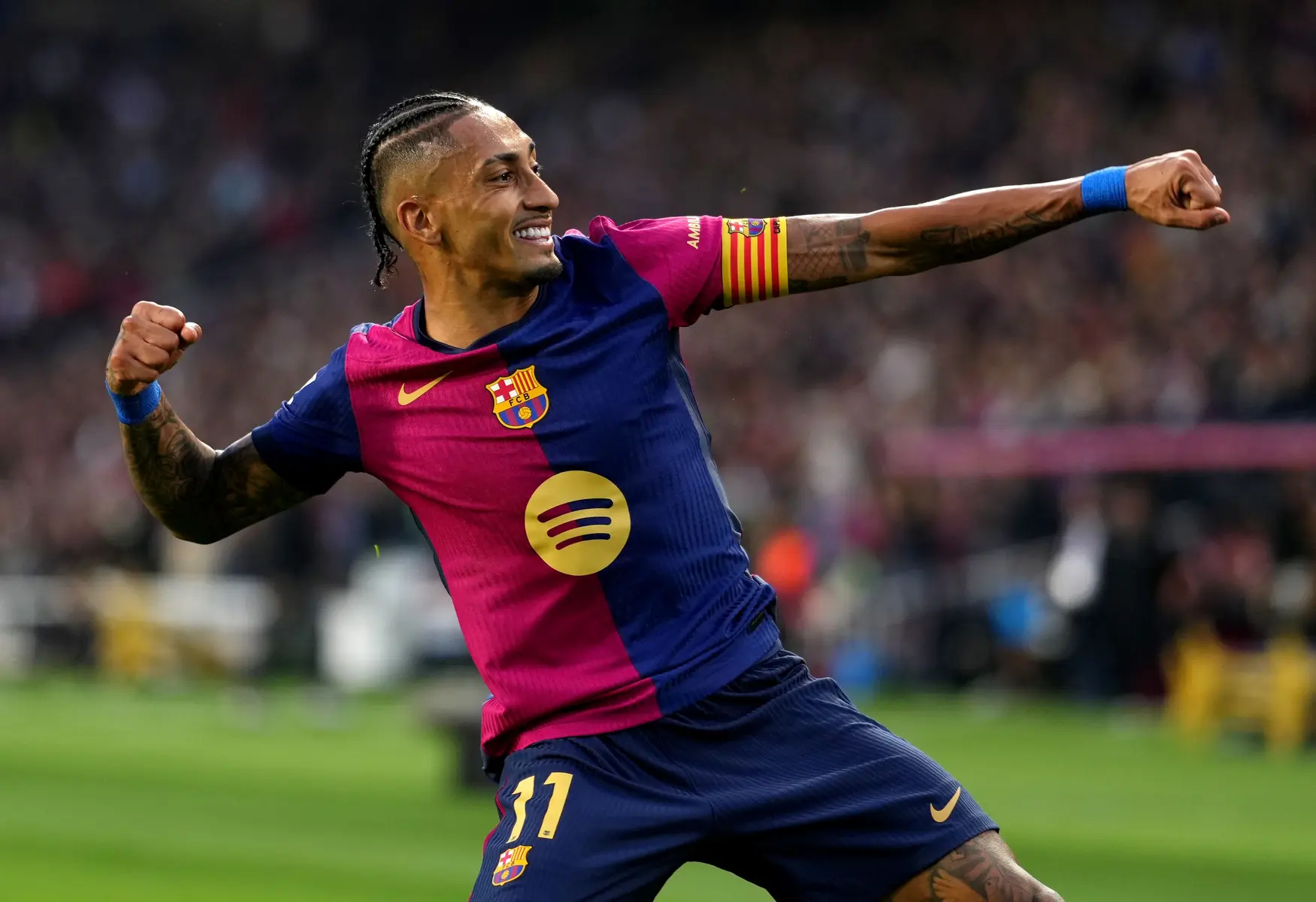 Raphinha celebrating a goal while wearing the FC Barcelona home kit