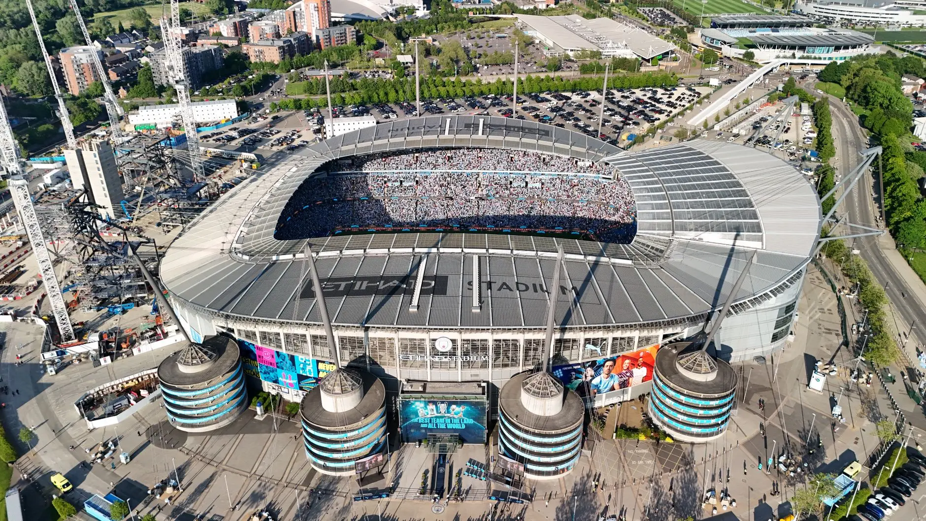 Aerial view of the Etihad Stadium, home of Manchester City, with fans filling the stands.